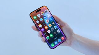 Close up of an iPhone in someone's hand with the Siri screen border activated in iOS 18