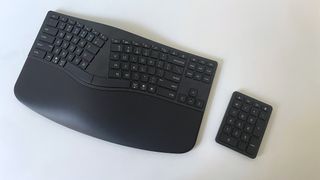 The HP 960 Ergonomic Keyboard with numpad seen from overhead on a white desk